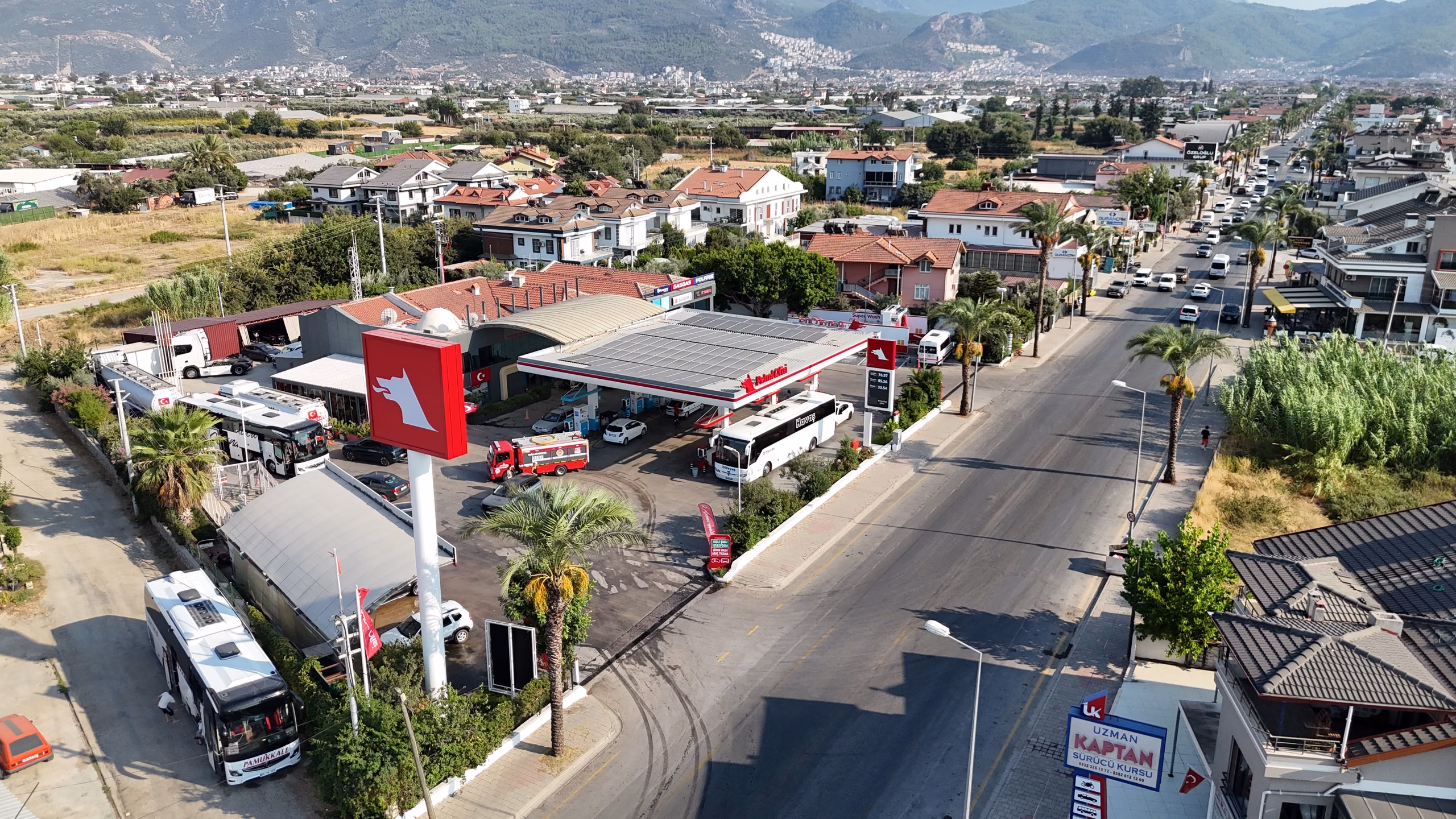 Günlükbaşı Petrol Ofisi istasyonunun havadan görünümü — kanopi, akaryakıt adaları ve Fethiye çevresi (24/24)