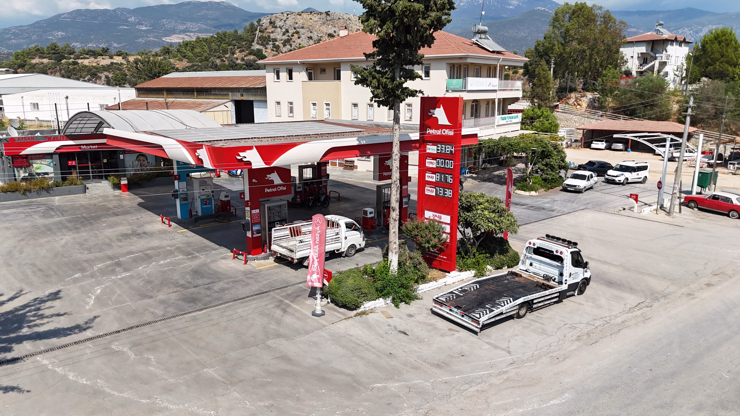 Karaköy Petrol Ofisi istasyonunun havadan görünümü — kanopi, akaryakıt adaları ve Seydikemer çevresi (9/11)