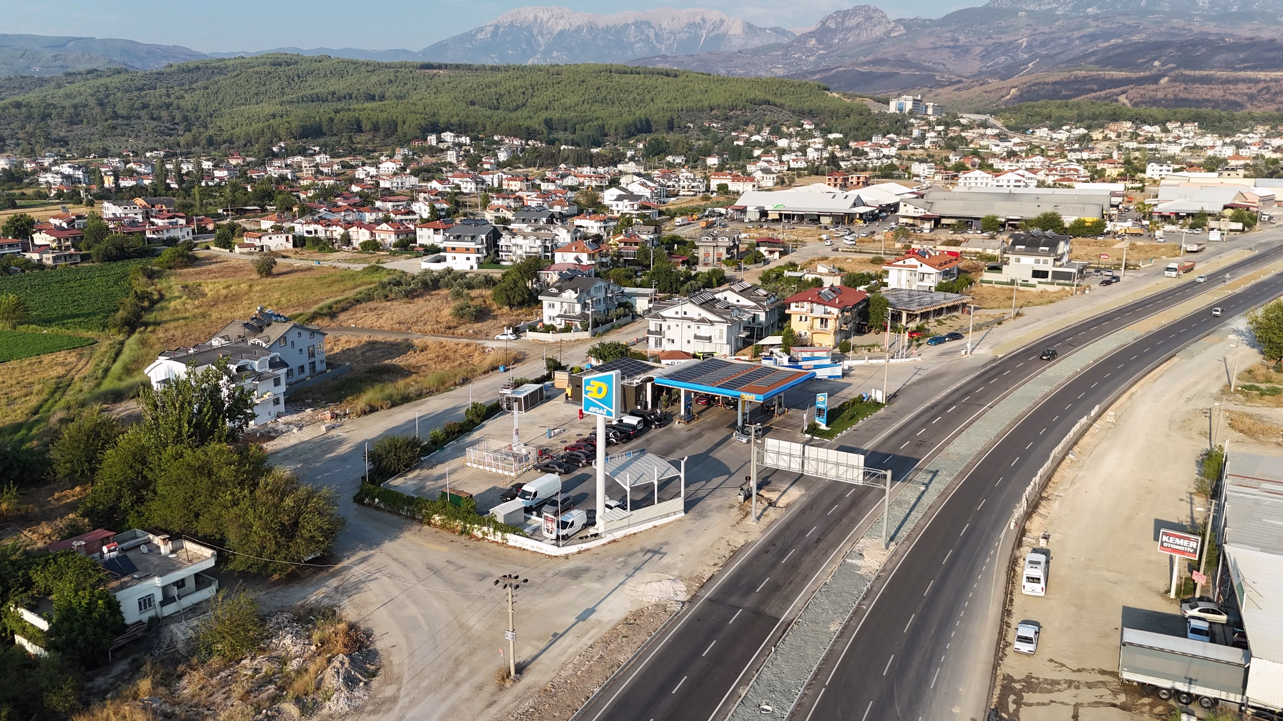 Seydikemer Opet istasyonunun havadan görünümü — kanopi, akaryakıt adaları ve Seydikemer çevresi (9/11)